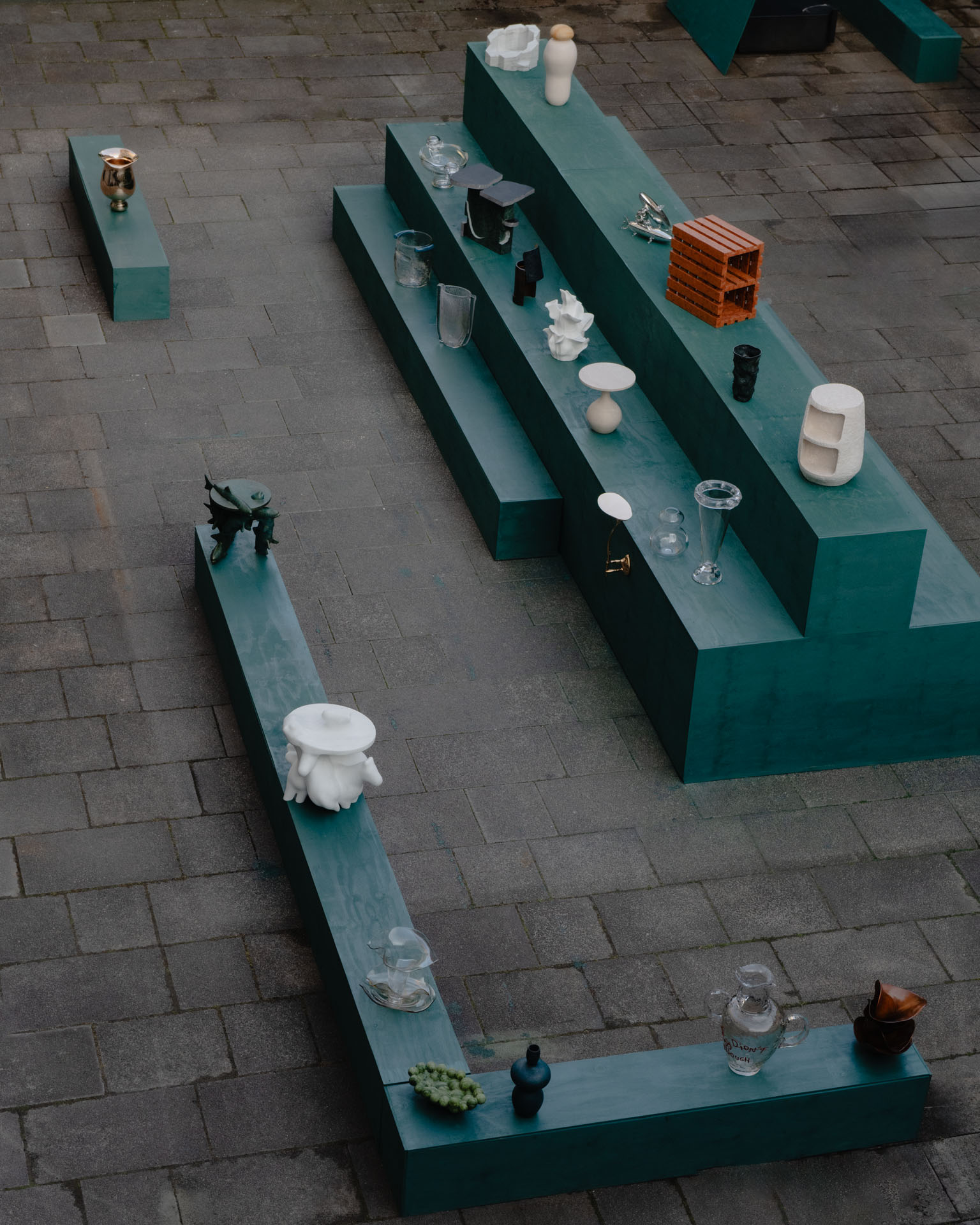Overhead view of green plinths displaying collectible objects from the Materia 2025 cohort