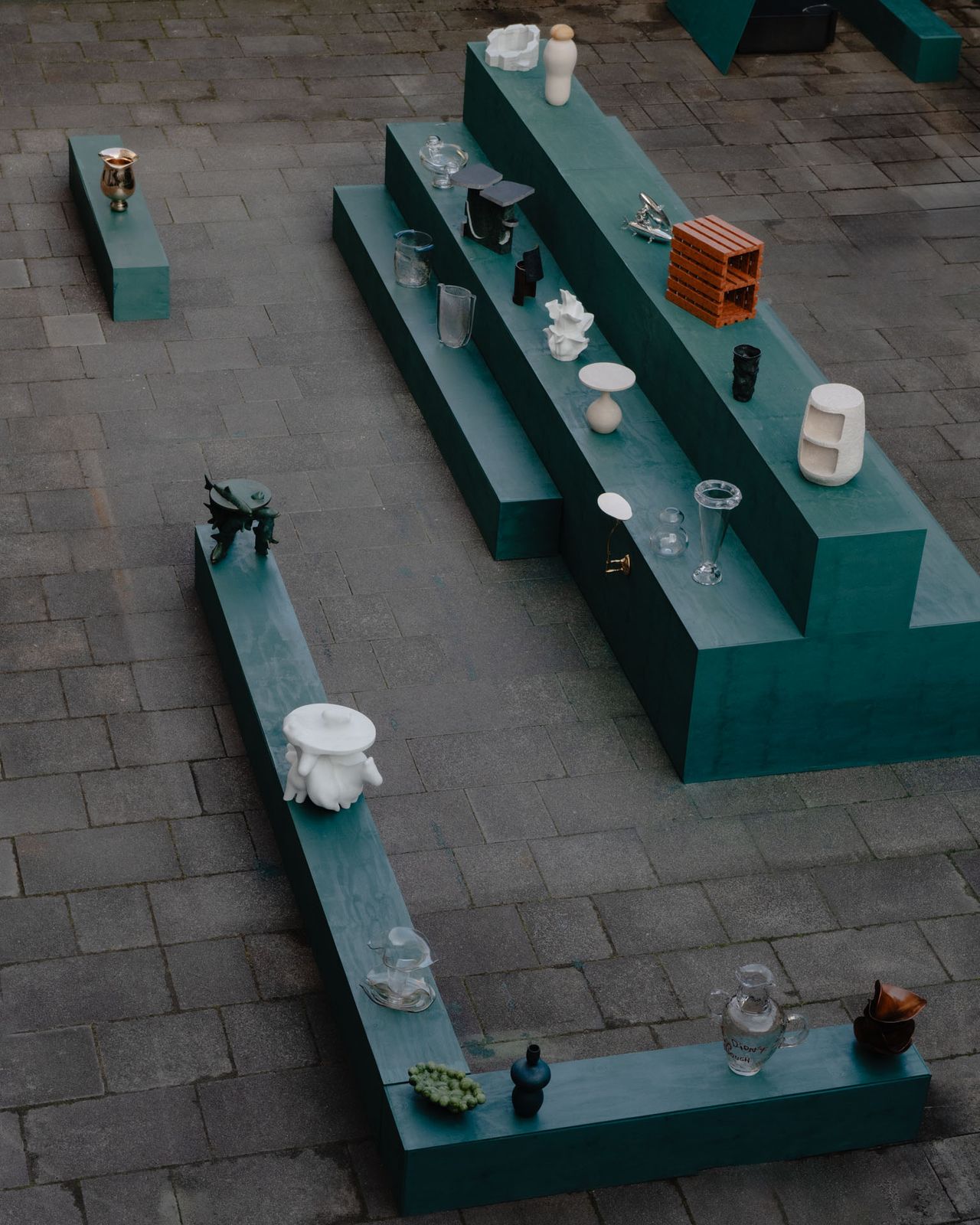 Overhead view of green plinths displaying collectible objects from the Project Materia 2025 cohort
